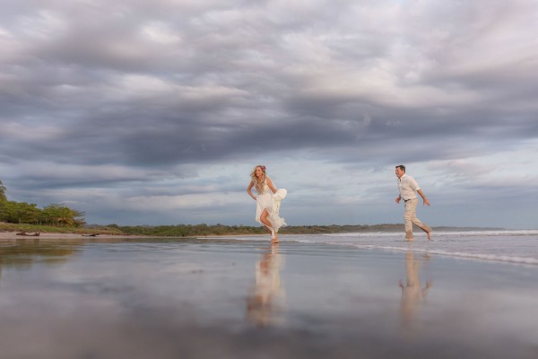 Pareja de boda corriendo en la playa en Costa Rica
